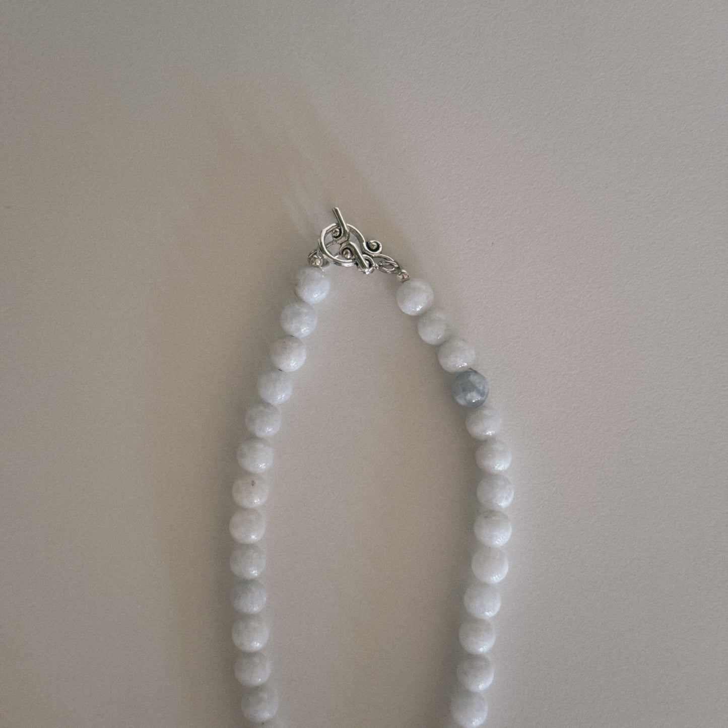 pale blue beaded necklace with mother of pearl shell