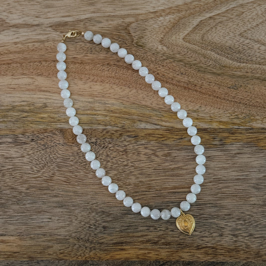 white glass beaded necklace with brass heart charm with horseshoe and "good luck" and 18k gold filled lobster clasp