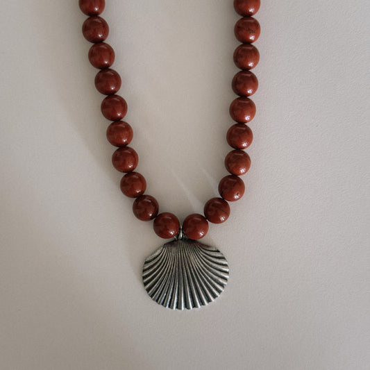 red beaded necklace with shell pendant