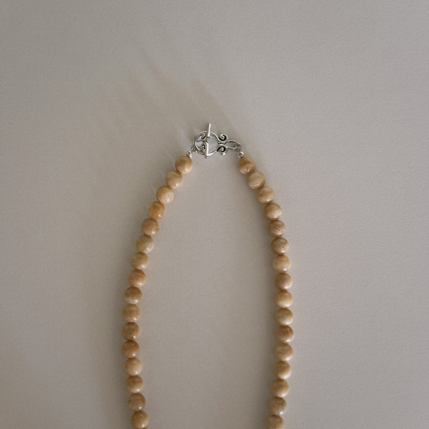 yellow beaded necklace with shell pendant