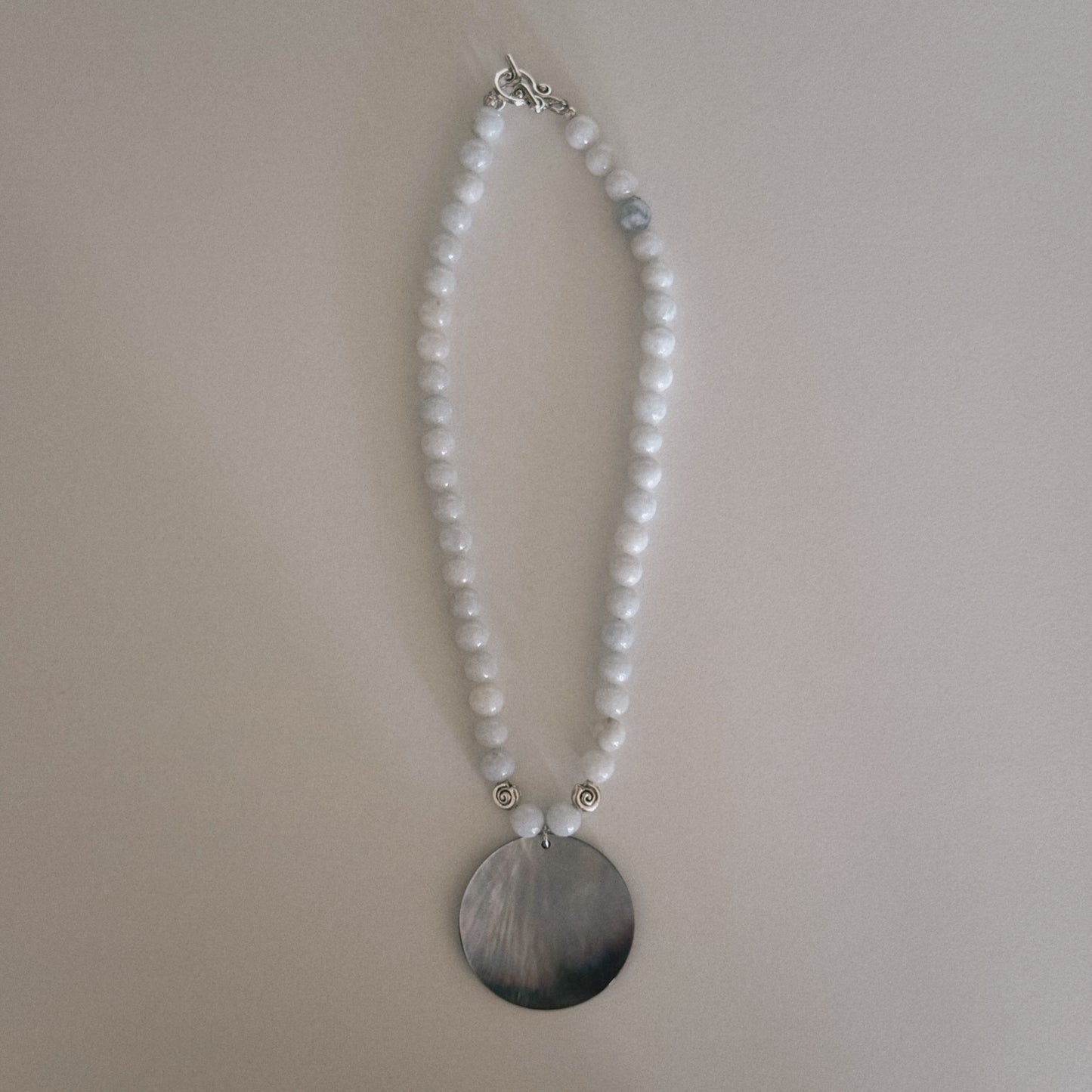 pale blue beaded necklace with mother of pearl shell