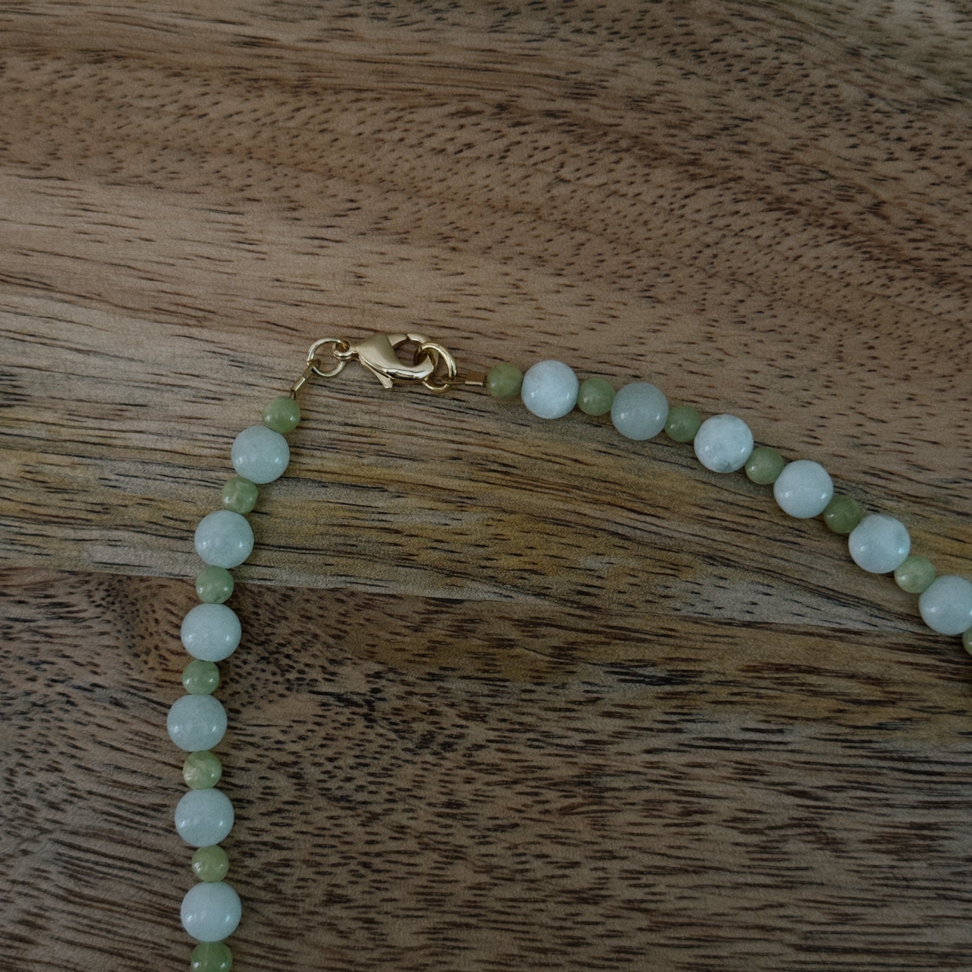 green and blue glass beaded necklace with brass seashell charm and 18k gold filled lobster clasp