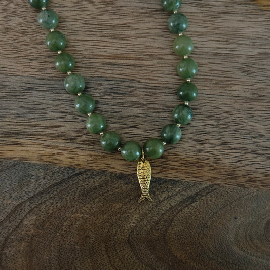 green and gold beaded necklace with brass fish charm and gold lobster clasp