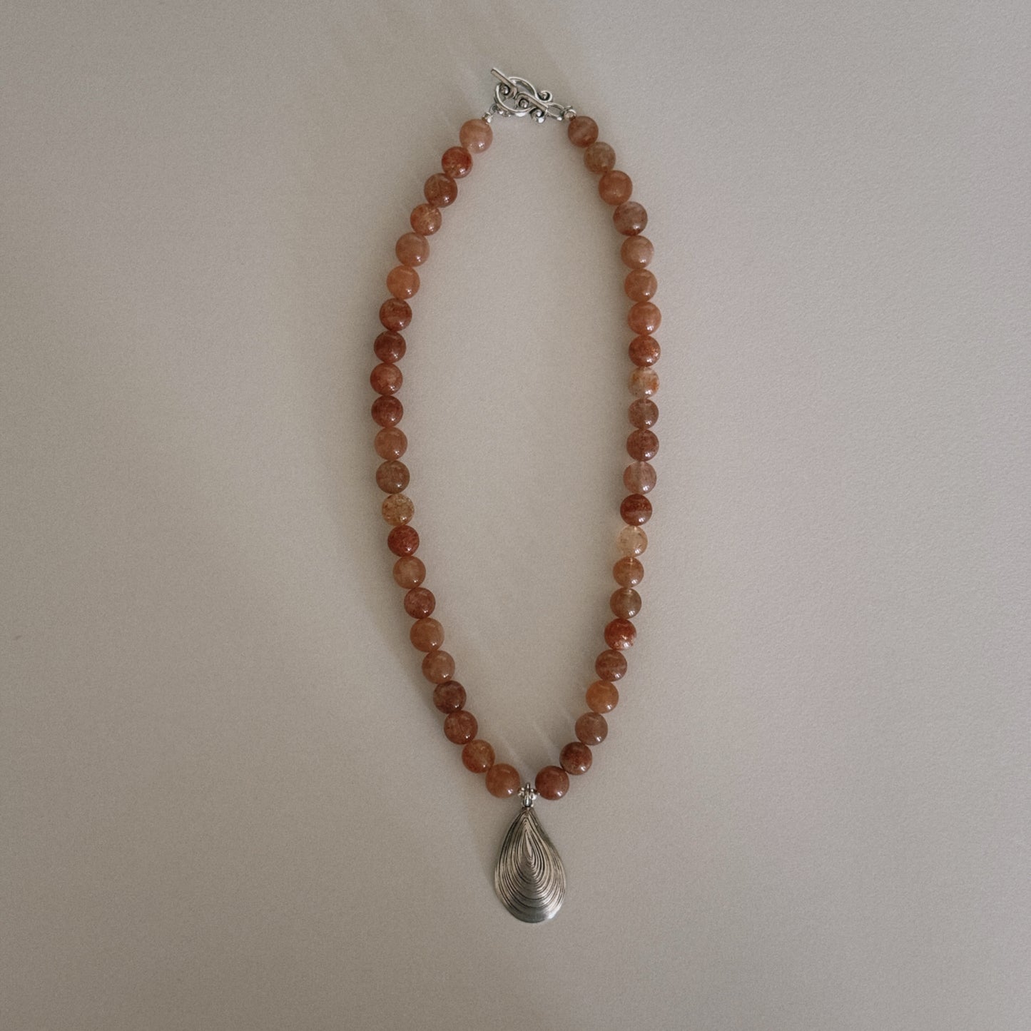 pink sunstone beaded necklace with oyster pendant
