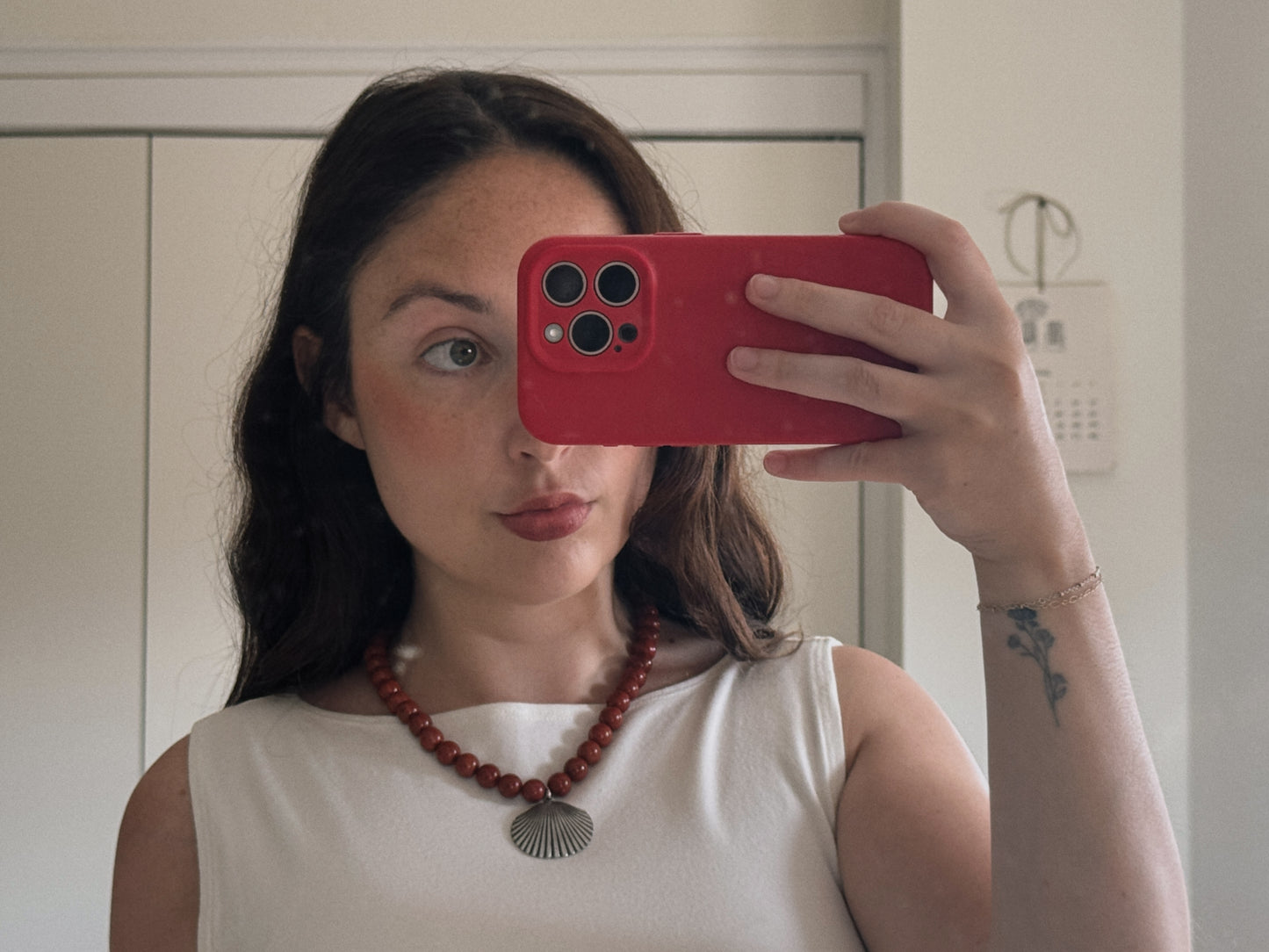 red beaded necklace with shell pendant