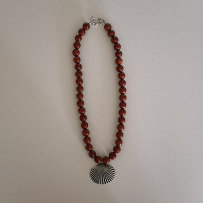 red beaded necklace with shell pendant