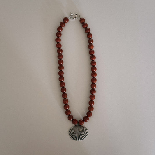 red beaded necklace with shell pendant