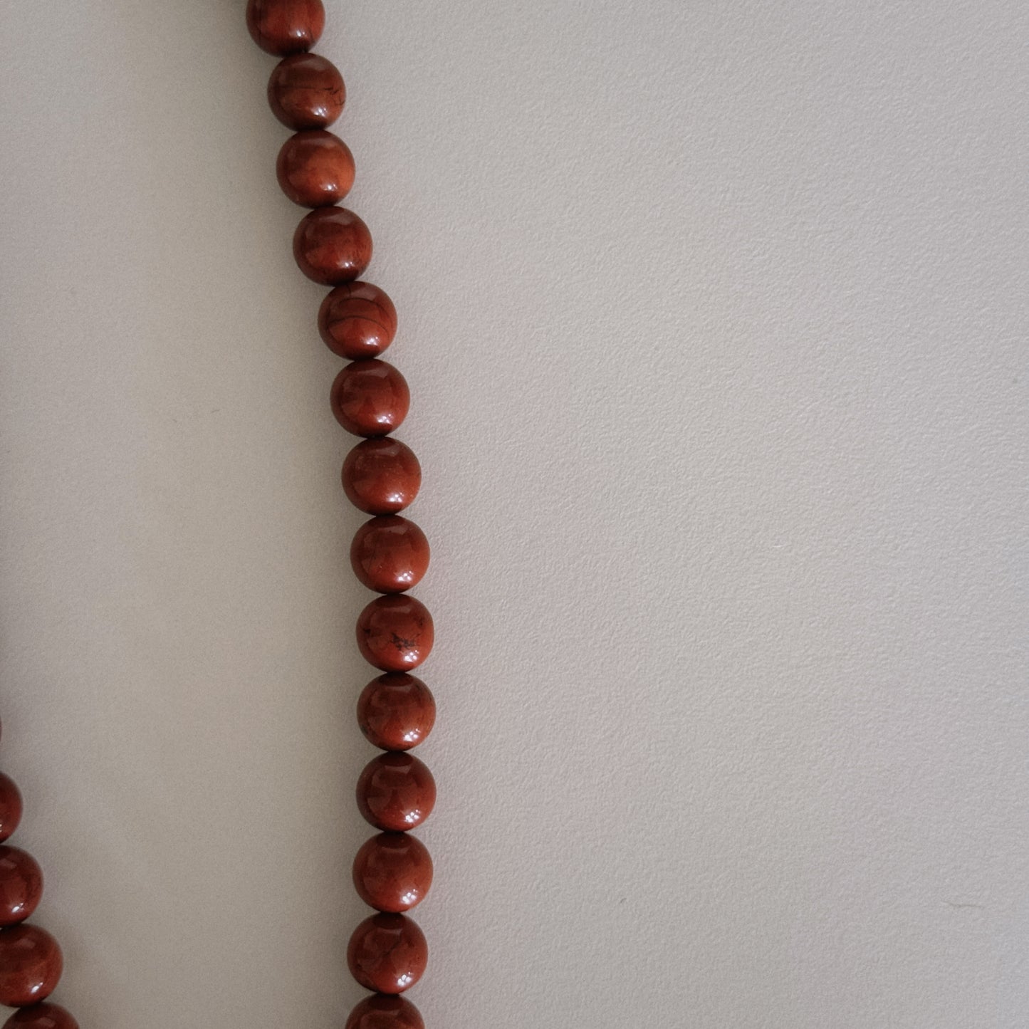 red beaded necklace with shell pendant