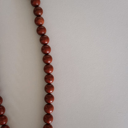 red beaded necklace with shell pendant