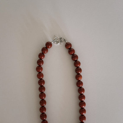 red beaded necklace with shell pendant