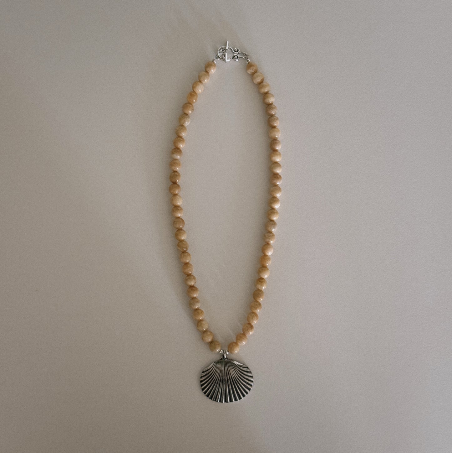 yellow beaded necklace with shell pendant