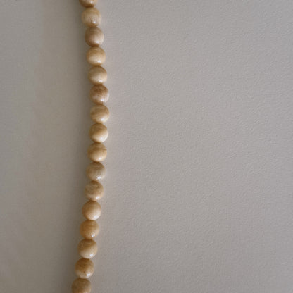 yellow beaded necklace with shell pendant
